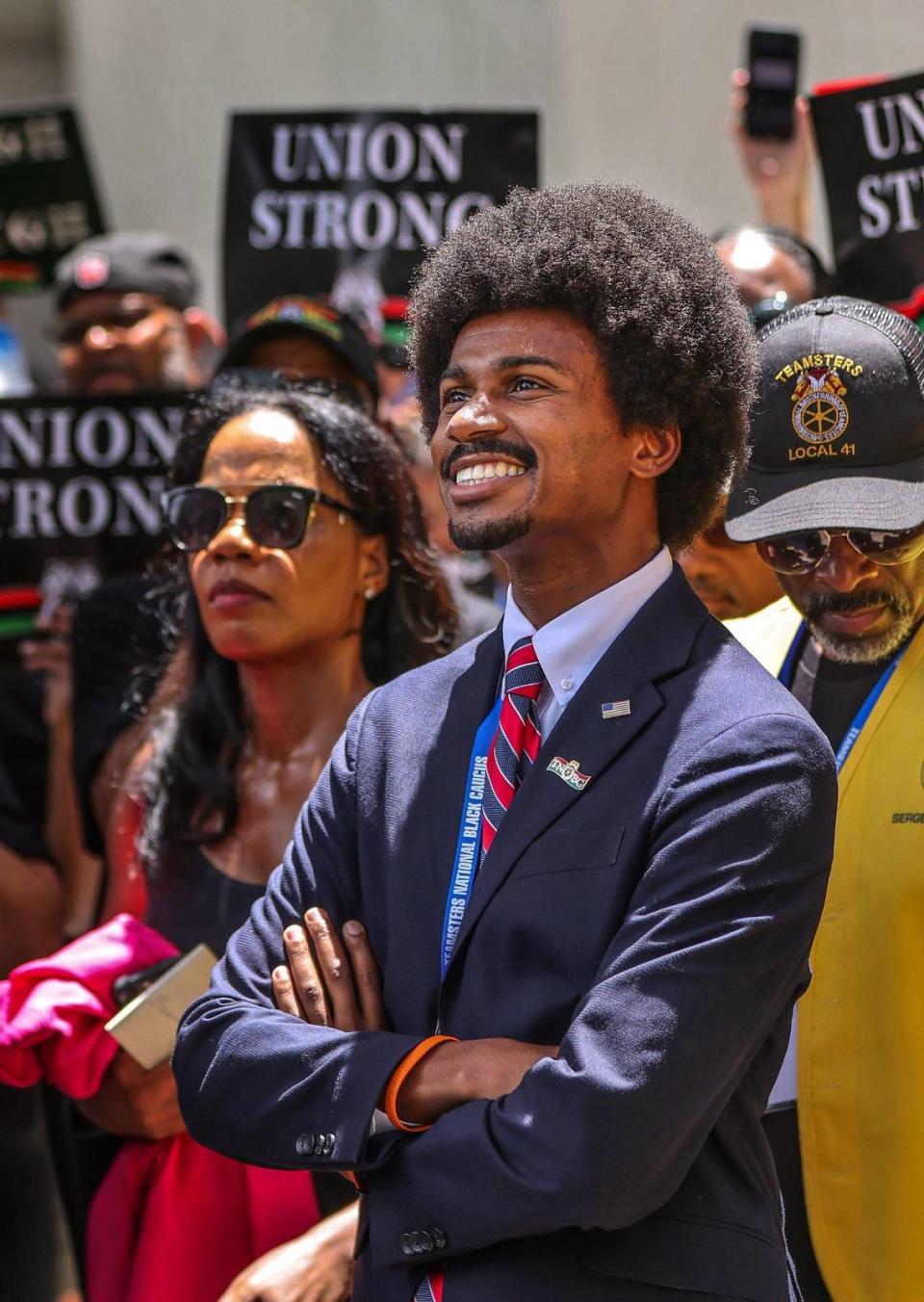 Tennessee Democrat State Rep. Justin Pearson, center, smiles as he awaits to take the stage during the demonstration outside the Miami-Dade County School Board administration building at a protest of the new African American history standards approved by the state in July, Wednesday, Aug. 16, 2023 in Miami, Florida. On the right is Marvin Dunn.