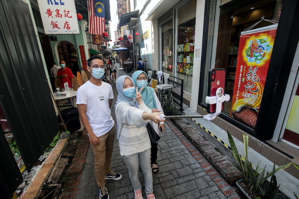 Nadhiereh Akmal from Putrajaya and her friends Danial Najmi and Aina Madhihah Jamil at Concubine Lane in Ipoh. — Picture by Farhan Najib