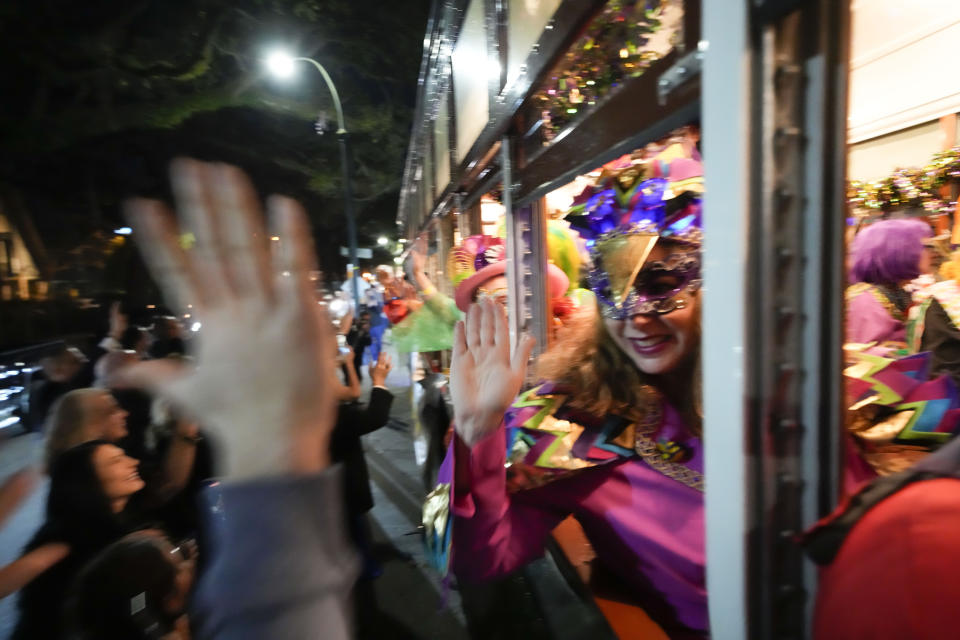 Members of the Mardi Gras group The Phunny Phorty Phellows revel with people on the street as they ride on a street car for their annual kick off of the Mardi Gras season on Twelfth Night in New Orleans, Friday, Jan. 6, 2023. (AP Photo/Gerald Herbert)