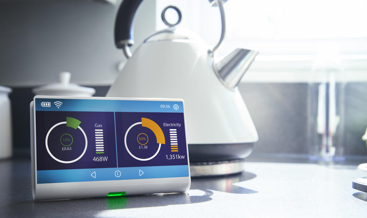 A smart meter on a kitchen work surface showing the households current energy consumption and costs