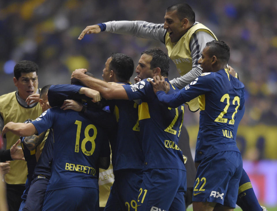 Dario Benedetto of Argentina's Boca Juniors (18) is surrounded by teammates after he scored their team's second goal during a Copa Libertadores semifinal first leg soccer match in Buenos Aires, Argentina, Wednesday, Oct. 24, 2018. (AP Photo/Gustavo Garello)