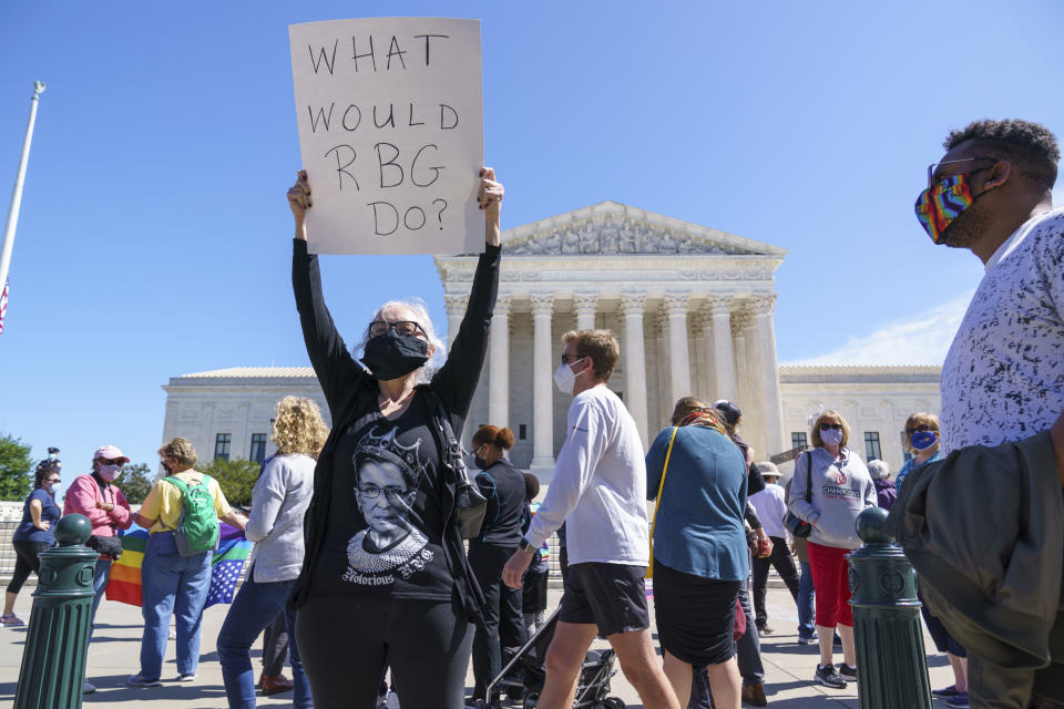 Kelli Midgley, center, an English teacher from Baltimore, joins people gathered at the Supreme Court to honor the late Justice Ruth Bader Ginsburg in Washington, Saturday, Sept. 19, 2020. Ginsburg's death leaves a vacancy that could be filled by a more conservative justice by President Donald Trump. (AP Photo/J. Scott Applewhite)