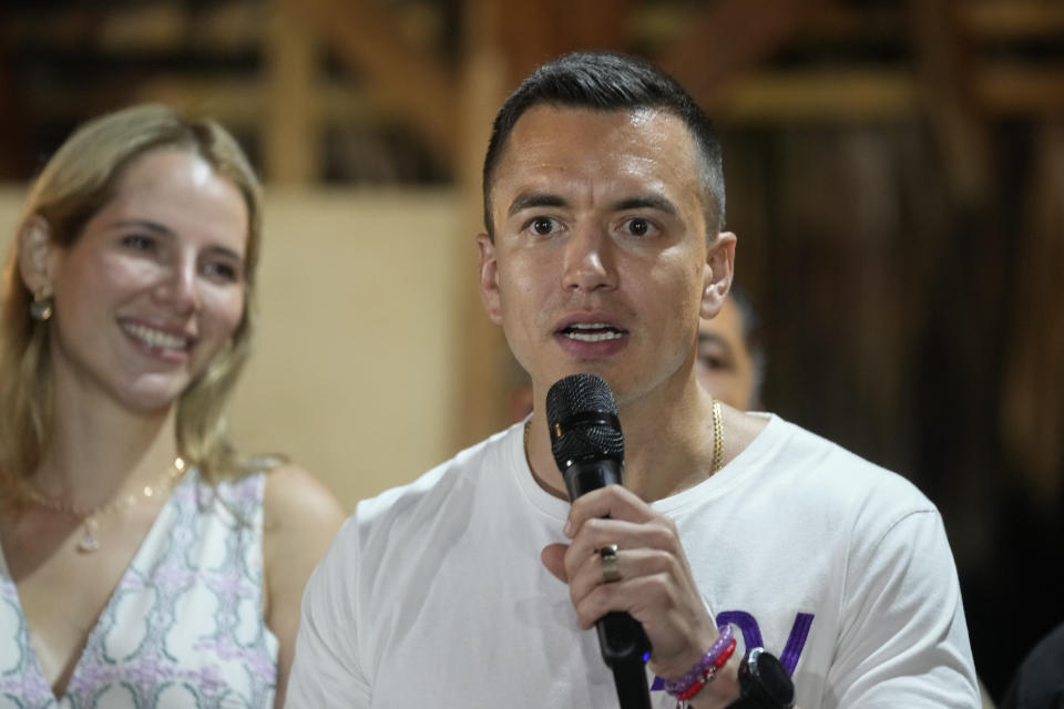Presidential candidate Daniel Noboa speaks in Olon, Ecuador, after results show him ahead in a snap presidential runoff on Sunday, Oct. 15, 2023. At left is his wife Lavinia Valbonesi. (AP Photo/Martin Mejia)