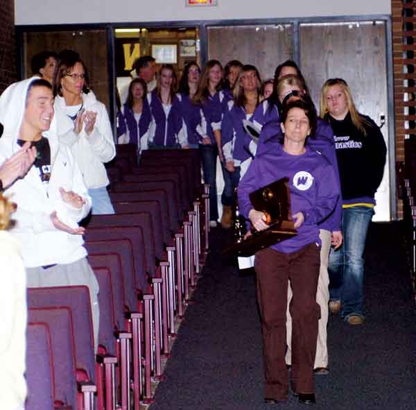 Co-head coach Melissa Van Gilder and the Watertown High School gymnastics squad arrive in the D.D. Miller Auditorium Sunday during a welcome home celebration for the team, which won its second straight state Class AA championship in 2012 at Aberdeen. Van Gilder, now again back as Watertown's assistant coach this winter, placed in the state gymnastics meet as a high school gymnast in Britton (Melissa St. Sauver).