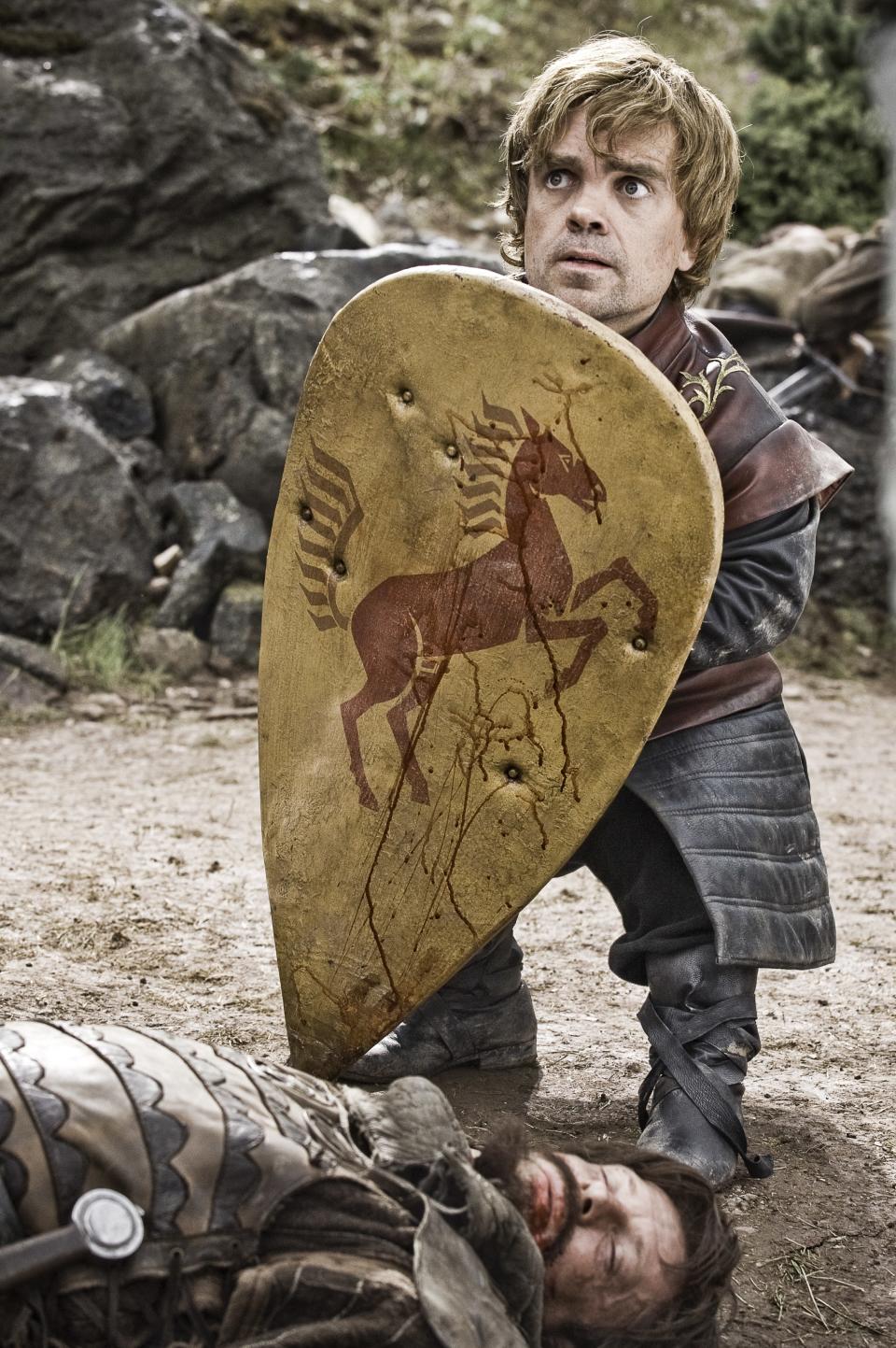 In his first appearances in Season 1, Tyrion was young and reckless, often using his family connections as a sort of a shield, to excuse all manner of excesses, and it shows up in his costuming. Notice how blond <strong>Peter Dinklage</strong>'s hair is, here — that's that Lannister gold — and how he's clean-shaven, untouched by battle, with a padded leather coat touched with crimson that seems more for show than it is intended to protect him in battle.