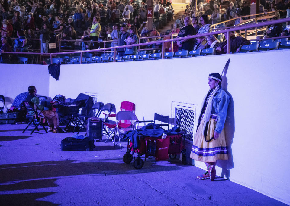 Cheyenne Reuben Thomas of the Oneida Nation in Alberta, Canada, looks on as dancers enter the arena for the grand entry at the 40th anniversary of the Gathering of Nations Pow Wow in Albuquerque, N.M., Friday, April 28, 2023. The annual Gathering of Nations kicked off Friday with a colorful procession of Native American and Indigenous dancers from around the world moving to the beat of traditional drums as they fill an arena at the New Mexico state fairgrounds. (AP Photo/Roberto E. Rosales)