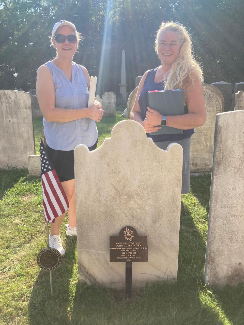 Michele Donnelly and Kristen Samuelsen-Sussman of the Middletown Daughters of the American Revolution chapter stand behind John Covenhoven's grave.