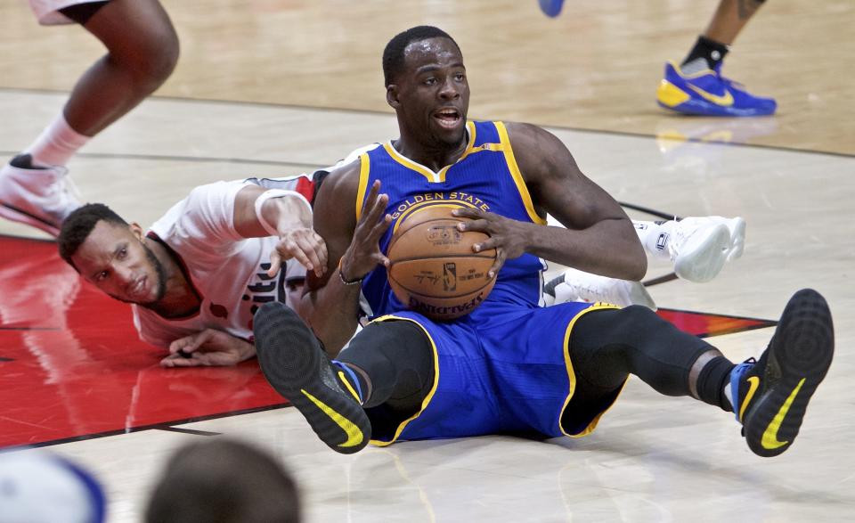 Golden State Warriors forward Draymond Green, right, and Portland Trail Blazers guard Evan Turner dive for a loose ball during the second half of Game 3 of an NBA basketball first-round playoff series Saturday, April 22, 2017, in Portland, Ore. The Warriors won 119-113. (AP Photo/Craig Mitchelldyer)