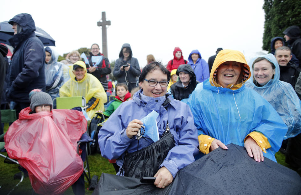 People wait for the arrival of Pope Francis in front of the Knock Shrine, in Knock, Ireland, Sunday, Aug. 26, 2018. Pope Francis is on a two-day visit to Ireland. (AP Photo/Peter Morrison)