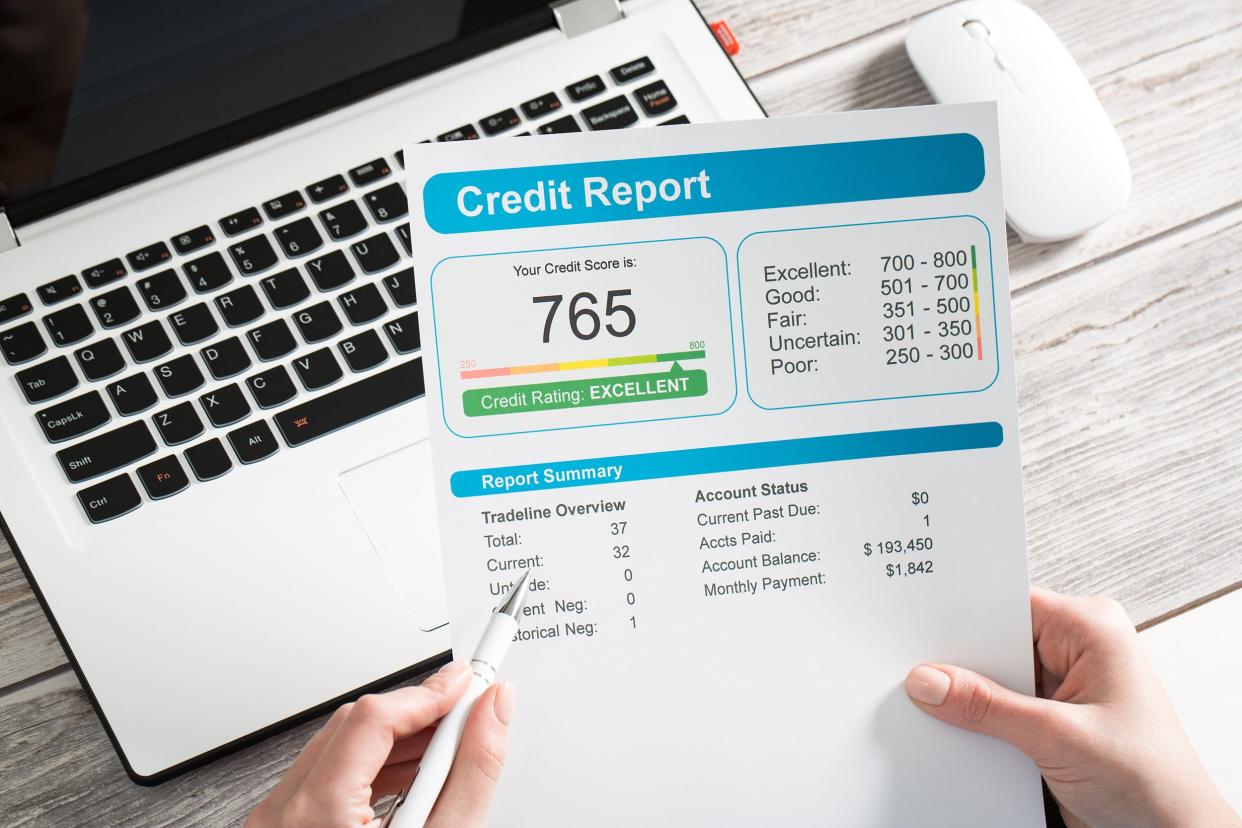 Credit score paper on a desk with a laptop