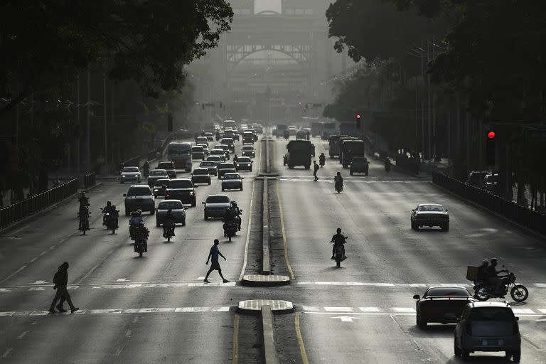 Automovilistas y peatones transitan por la avenida Bolívar al atardecer en Caracas