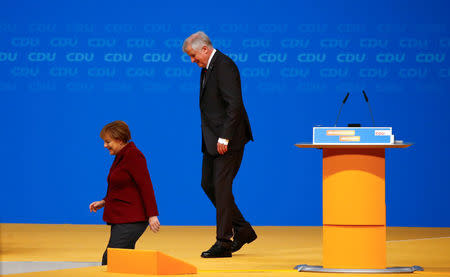 Bavarian Prime Minister and head of the Christian Social Union (CSU) Horst Seehofer follows German Chancellor and leader of the Christian Democratic Union (CDU) Angela Merkel as they leave the stage during the CDU party congress in Karlsruhe, Germany December 15, 2015. REUTERS/Kai Pfaffenbach/File Photo