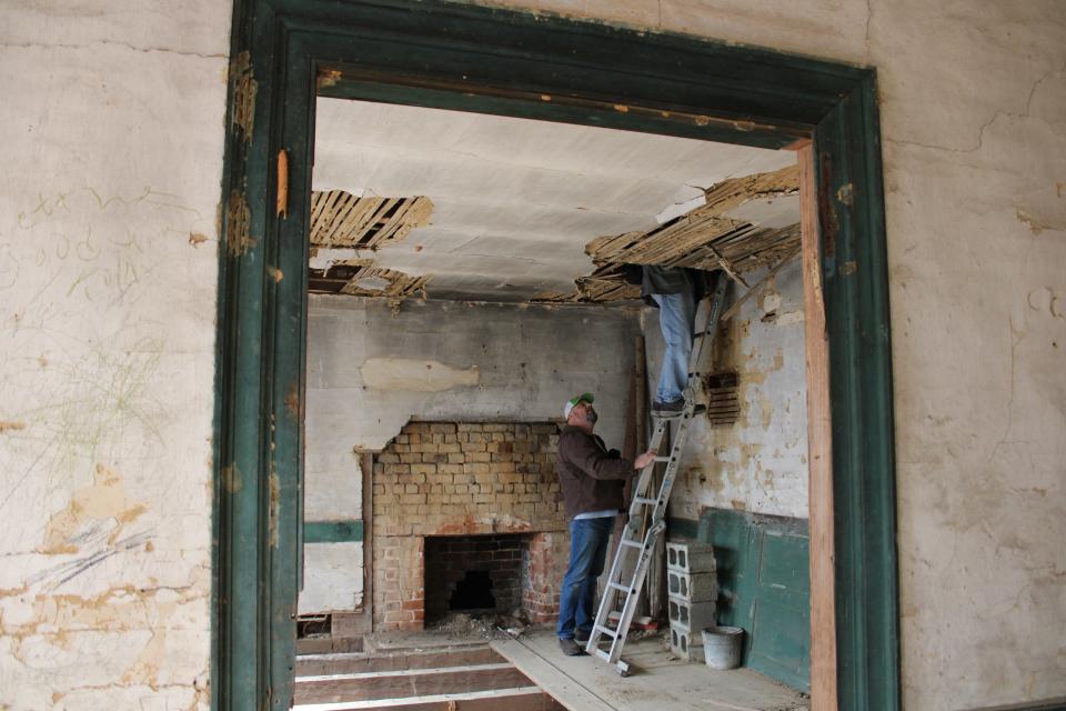 Richard "Richie" Blick holds a ladder for architectural historian Marc Wagner on the second floor of the historic Blick Plantation in Lawrenceville, Va.