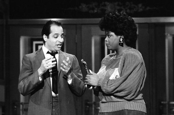 SATURDAY NIGHT LIVE — Episode 14 — Pictured: (l-r) Jon Lovitz as Tommy Flanagan, Oprah Winfrey during the monologue on April 14, 1986 (Photo by Alan Singer/NBCU Photo Bank/NBCUniversal via Getty Images via Getty Images)