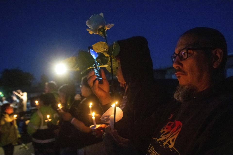 People gather at a memorial for high school student Jonathan Lewis Jr. near Rancho High School in eastern Las Vegas, on Tuesday, Nov. 21, 2023. Authorities have arrested at least eight students in connection with the beating of Lewis, who died a week after a prearranged fight broke out over a pair of headphones and a vape pen. (AP Photo/Ty O'Neil)