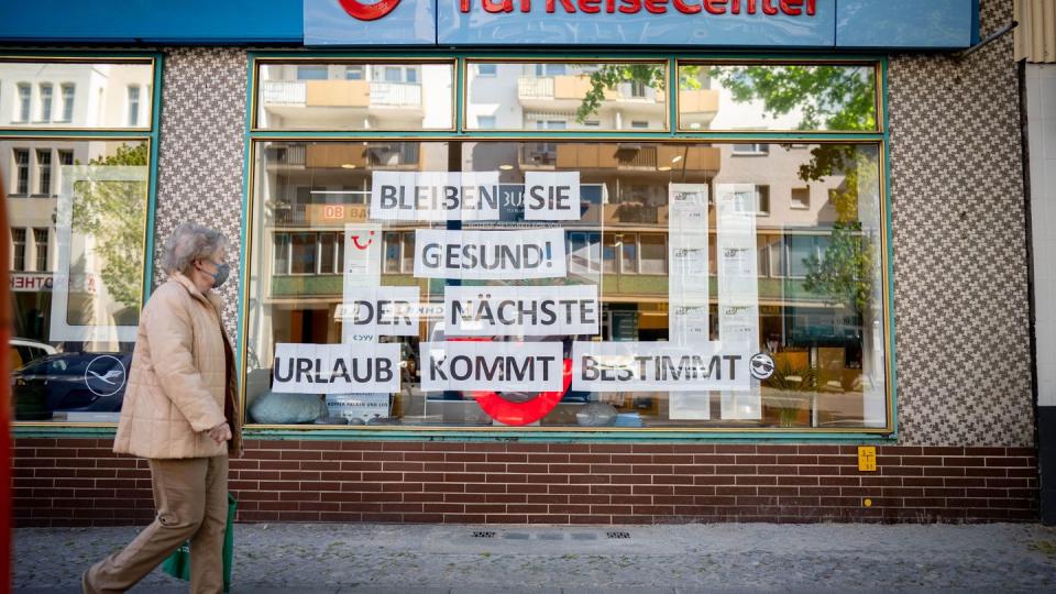 Eine aufmunternde Botschaft hängt im Fenster eines Reisebüros in Berlin.