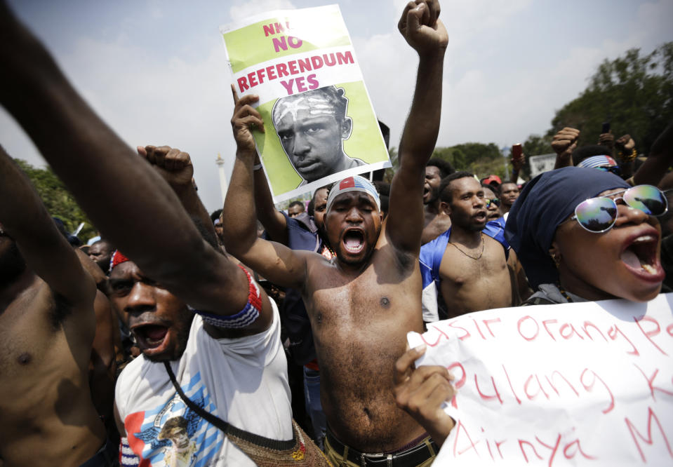 Papuan activists slogans during a rally near the presidential palace in Jakarta, Indonesia, Thursday, Aug. 22, 2019. A group of West Papuan students in Indonesia's capital staged the protest against racism and called for independence for their region. Writings on the poster say "Unitary State of the Republic of Indonesia No, Referendum Yes". (AP Photo/Dita Alangkara)