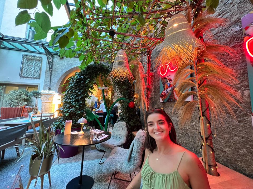 woman wearing a green dressing sitting in an outdoor courtyard