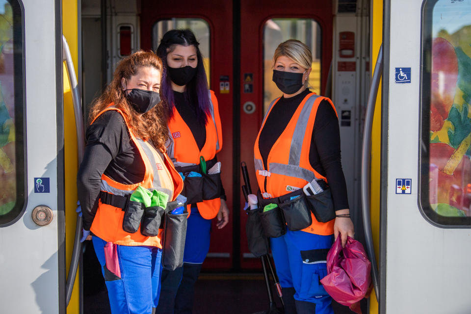 18 May 2020, Bavaria, Munich: Three cleaning staff of the mobile cleaning service of the Munich S-Bahn are standing in the door of a standing S-Bahn. As a team, the cleaning staff ensure that contact surfaces are properly disinfected during the corona period. Photo: Lino Mirgeler/dpa (Photo by Lino Mirgeler/picture alliance via Getty Images)