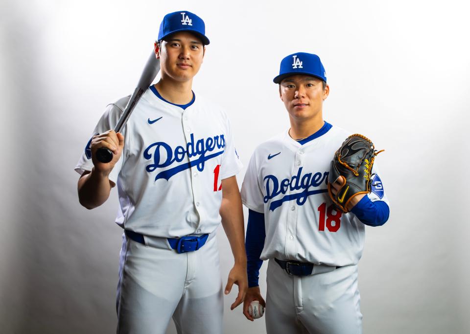 Los Angeles Dodgers designated hitter Shohei Ohtani (left) and pitcher Yoshinobu Yamamoto pose for a portrait during media day at Camelback Ranch. Both player's jerseys can be seen tucked into their pants.