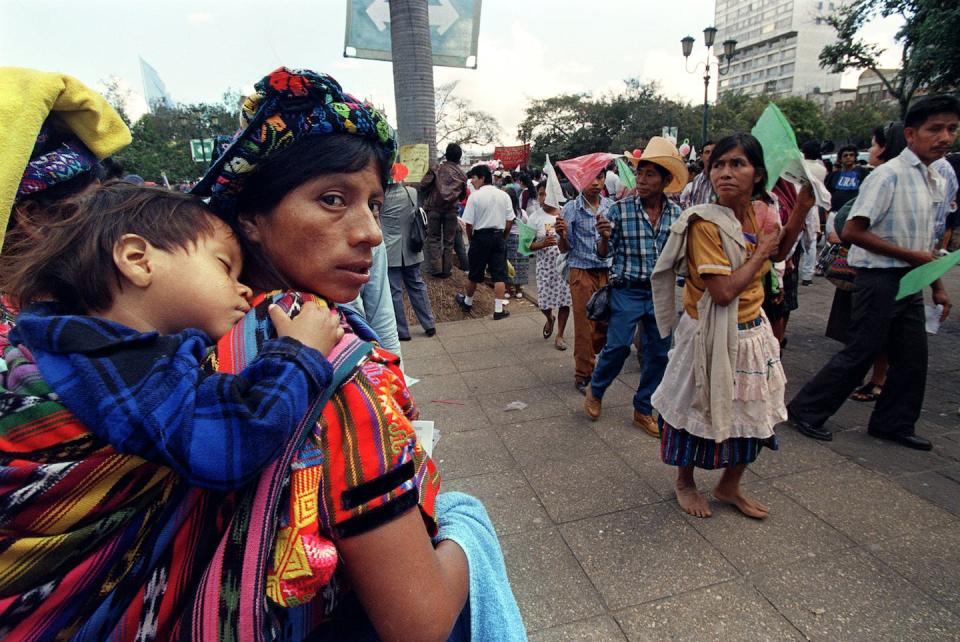 Guatemalans came to observe the peace-signing between the government and rebels in 1996, ending 36 years of civil war. <a href="https://media.gettyimages.com/photos/guatemalan-woman-watches-a-procession-of-mayan-communities-in-front-picture-id648698552" rel="nofollow noopener" target="_blank" data-ylk="slk:Rodrigo Arangua/AFP via Getty Images;elm:context_link;itc:0;sec:content-canvas" class="link ">Rodrigo Arangua/AFP via Getty Images</a>