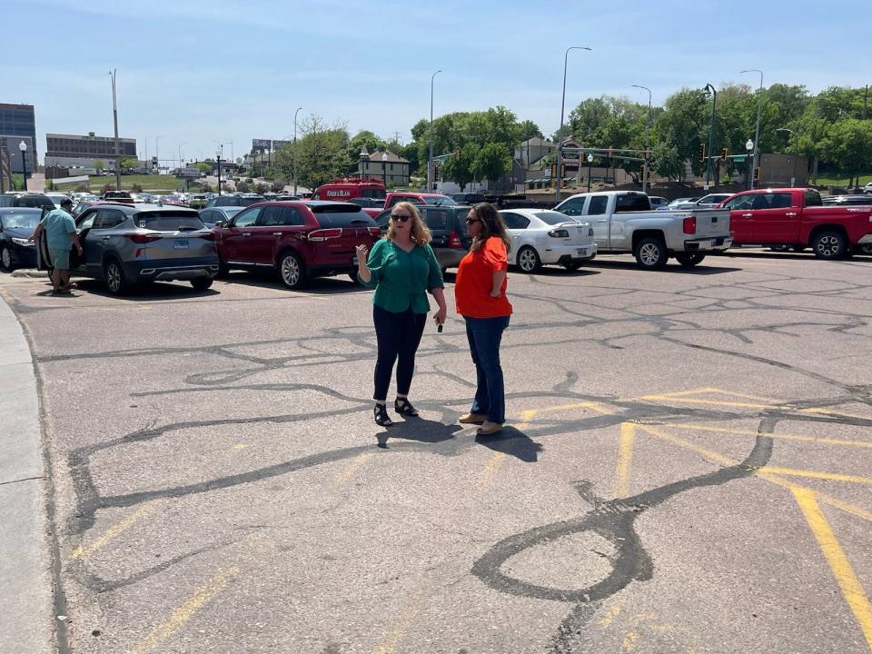 Pam Cole (left) and Tiffany Campbell of Dakotans for Health discuss petition circulation strategy on the edge of the designated area recently assigned by the Minnehaha County Commission.