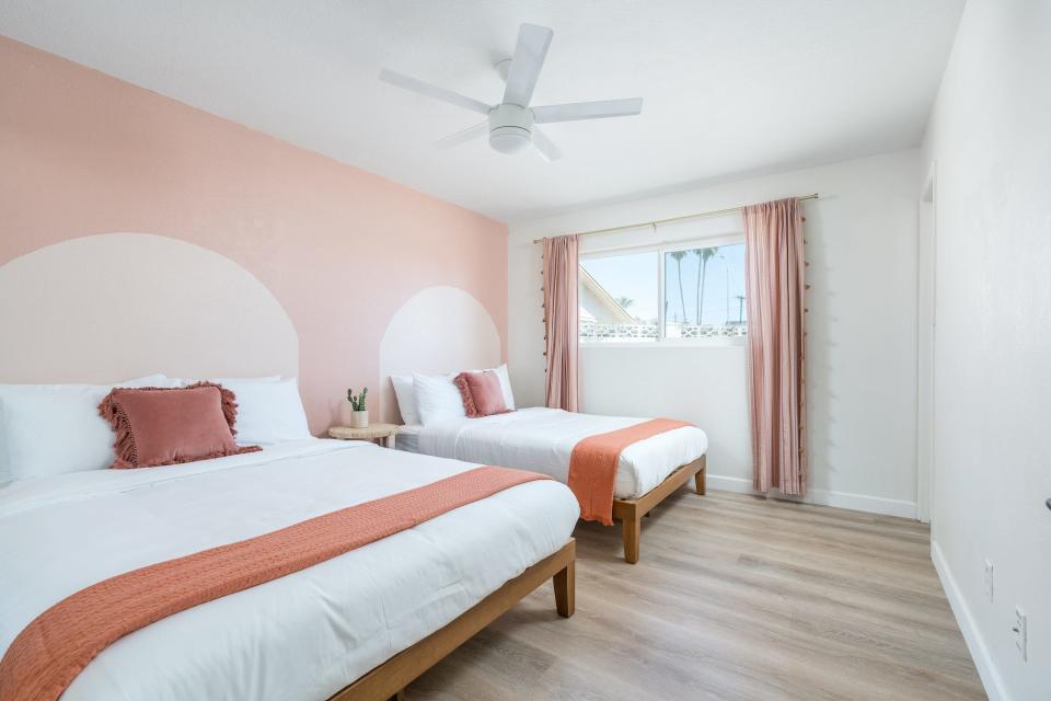 Ein Schlafzimmer mit zwei Queensize-Betten und an die Wände gemalten Bögen. - Copyright: Jakson Sharp