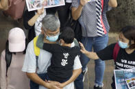 A man holds a boy wearing a shirt reading "Hong Kong" during a rally to protest against the exposure of children to tear gas by police in Hong Kong, Saturday, Nov. 23, 2019. President Donald Trump on Friday wouldn't commit to signing bipartisan legislation supporting pro-democracy activists in Hong Kong as he tries to work out a trade deal with China. (AP Photo/Ng Han Guan)