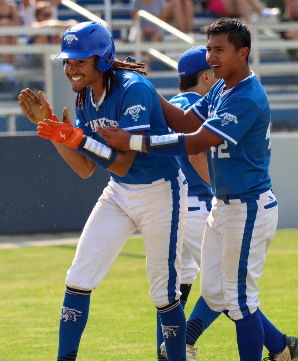 Frankfort's Quentcy Perry celebrates with Alex Lopez (42) following an early scored run in the Class 3A regional championship against Mishawaka Marian.