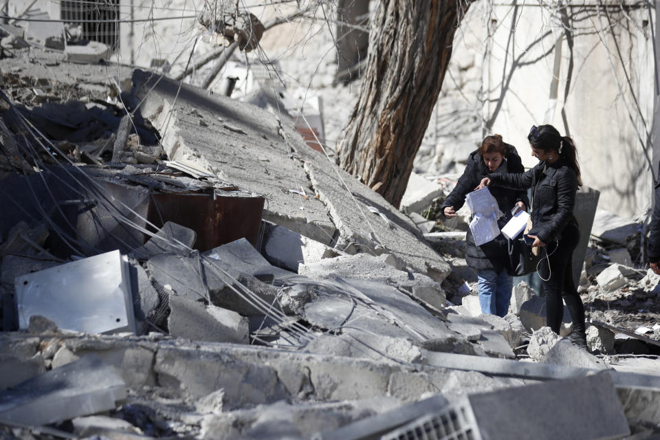 Syrian inspect the damage of a medieval citadel and an applied arts institute house after an early morning Israeli airstrike in the capital city of Damascus, Syria, Sunday, Feb. 19, 2023. Syrian state news reported that Israeli airstrikes have targeted a residential neighborhood in central Damascus. (AP Photo/Omar Sanadiki)