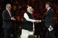 Indian Prime Minister Narendra Modi, center, shakes hands with New South Wales Premier Chris Mines as Australian Prime Minister Anthony Albanese, left, looks on during an Indian community event at Qudos Bank Arena in Sydney, Australia, Tuesday, May 23, 2023. Modi has arrived in Sydney for his second Australian visit as India's prime minister and told local media he wants closer bilateral defense and security ties as China's influence in the Indo-Pacific region grows. (AP Photo/Mark Baker)