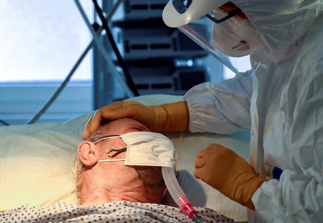 A medical staff member is seen next to a patient suffering from the coronavirus disease (COVID-19) in the intensive care unit at the Circolo hospital in Varese, Italy April 9, 2020.