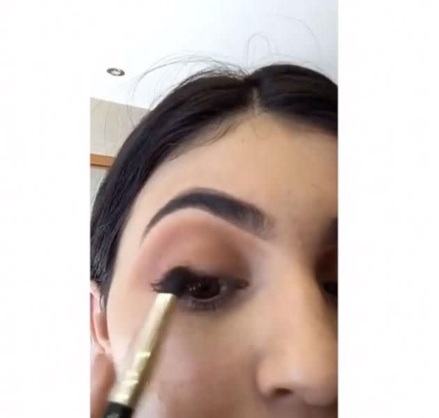 Kylie applying darker brown liner. Source: Snapchat