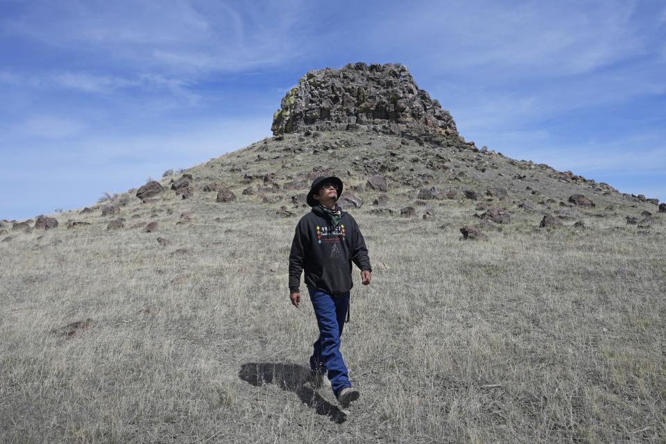 Gary McKinney, a spokesman for People of Red Mountain and a member of the nearby Duck Valley Shoshone-Paiute Tribe, walks near Sentinel Rock on April 25, 2023, outside of Orovada, Nev. A huge lithium mine under construction in northern Nevada is at the center of a dispute over President Joe Biden's clean energy agenda. McKinney said the project will cause irreparable damage. (AP Photo/Rick Bowmer)