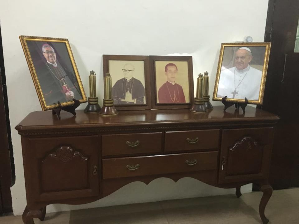 A table with the photographs of Pope Francis and the Archbishop of Singapore, William Goh Seng Chye (far left).