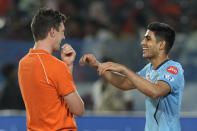 Gujarat Titans' captain Shubman Gill, right, chats with Sunrisers Hyderabad's captain Pat Cummins as the Indian Premier League cricket match between Gujrat Titans and Sunrisers Hyderabad is delayed due to rain in Hyderabad, India, Thursday, May 16, 2024. (AP Photo /Mahesh Kumar A.)