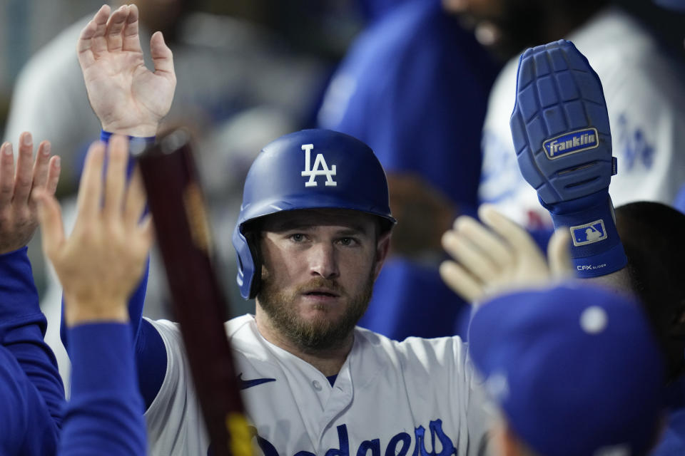 Los Angeles Dodgers' Max Muncy celebrates in the dugout after scoring off of a double hit by designated hitter J.D. Martinez during the third inning of a baseball game against the San Francisco Giants in Los Angeles, Saturday, Sept. 23, 2023. Mookie Betts also scored. (AP Photo/Ashley Landis)