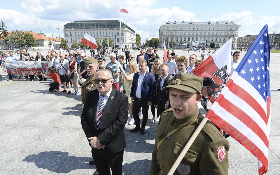 Polish officials and war veterans pay tribute to a World War II-era underground force that collaborated with Nazi German forces toward the end of the war in their battle against the Communists, who were imposing control on the nation, in Warsaw, Poland, Sunday, Aug. 11, 2019. President Andrzej Duda's official patronage and the presence of ruling party officials underlined the right-wing government's rehabilitation of a partisan unit that fought both Germans and Soviets and which is celebrated by the far right. (AP Photo/Czarek Sokolowski)