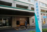 A man wearing a protective face mask, following an outbreak of the coronavirus disease walks past in front of Eiju General Hospital in Tokyo, Japan