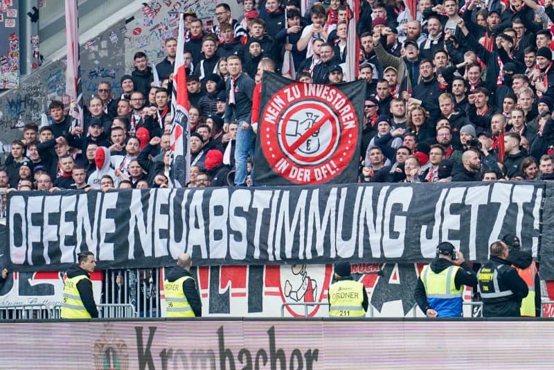 Stuttgart fans hold banners with the words "No to investors in the DFL" and "Open new vote now!"  in protest against the German Football League's (DFL) plans to bring in investors, during the German Bundesliga soccer match between SV Darmstadt 98 and VfB Stuttgart at the Merck-Stadion am Boellenfalltor. Uwe Anspach/dpa