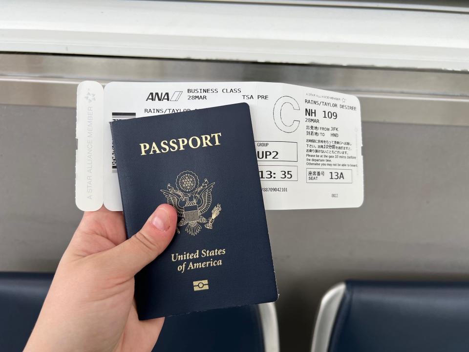 The author holding her passport and boarding pass.