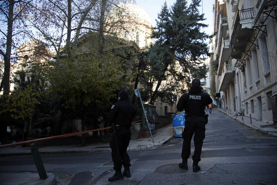 Police guard after an explosion outside the Orthodox church of Agios Dionysios in the upscale Kolonaki area of Athens, Thursday, Dec. 27, 2018. Police in Greece say an officer has been injured in a small explosion outside a church in central Athens while responding to a call to investigate a suspicious package. (AP Photo/Thanassis Stavrakis)