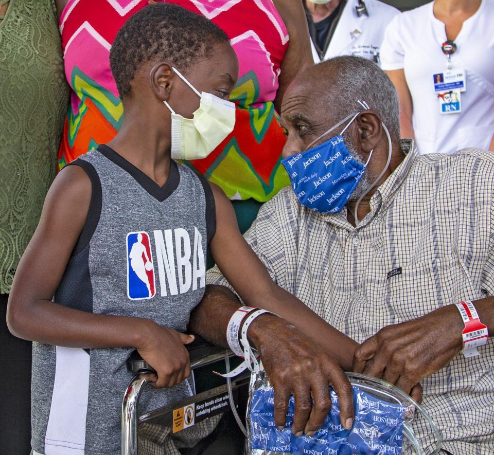 James Gardner, 77, goes home after battling COVID-19 for a month at Jackson South Medical Center on Thursday, Aug. 27, 2020 in Miami. His family arrived to take him home including his adopted son Shaquille Gross, 7. (Al Diaz/Miami Herald via AP)