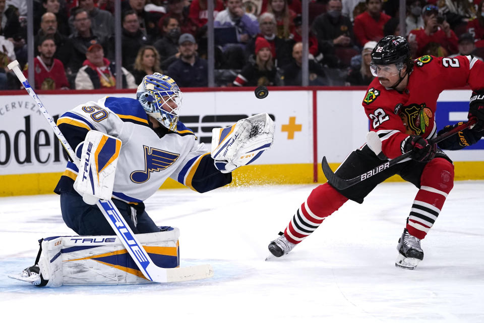 St. Louis Blues goaltender Jordan Binnington, left, makes a save on a shot against Chicago Blackhawks center Ryan Carpenter during the first period of an NHL hockey game in Chicago, Friday, Nov. 26, 2021. (AP Photo/Nam Y. Huh)
