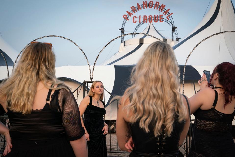 Jennifer DeMattei, 23, of Troy, center, poses for a photograph taken by a friend before entering the Paranormal Cirque III outside of the Lakeside Mall in Sterling Heights on Thursday, August 24, 2023. “We love dark stuff and love paranormal stuff,” said DeMattei. “We saw it on Facebook and we definitely had to go.”