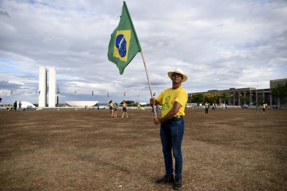 Un partidario del presidente Jair Bolsonaro, que aspira a ser reelegido, sostiene una bandera de Brasil tras el cierre de las urnas en la segunda vuelta electoral, el domingo 30 de octubre de 2022, en Brasilia, Brasil. (AP Foto/Ton Molina)