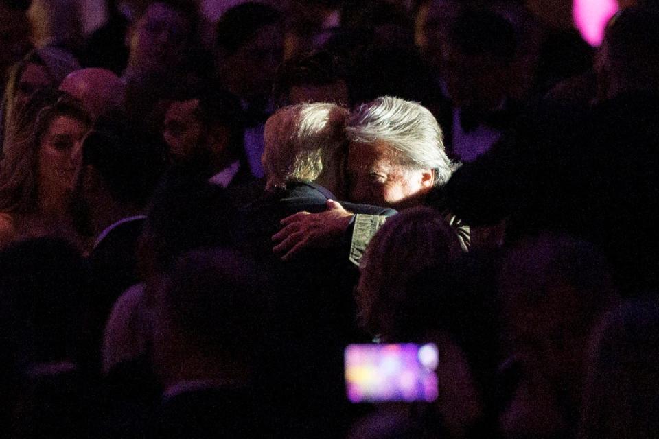 Donald Trump hugs his former chief strategist Steve Bannon at a New York Young Republicans gala on 9 December (EPA)