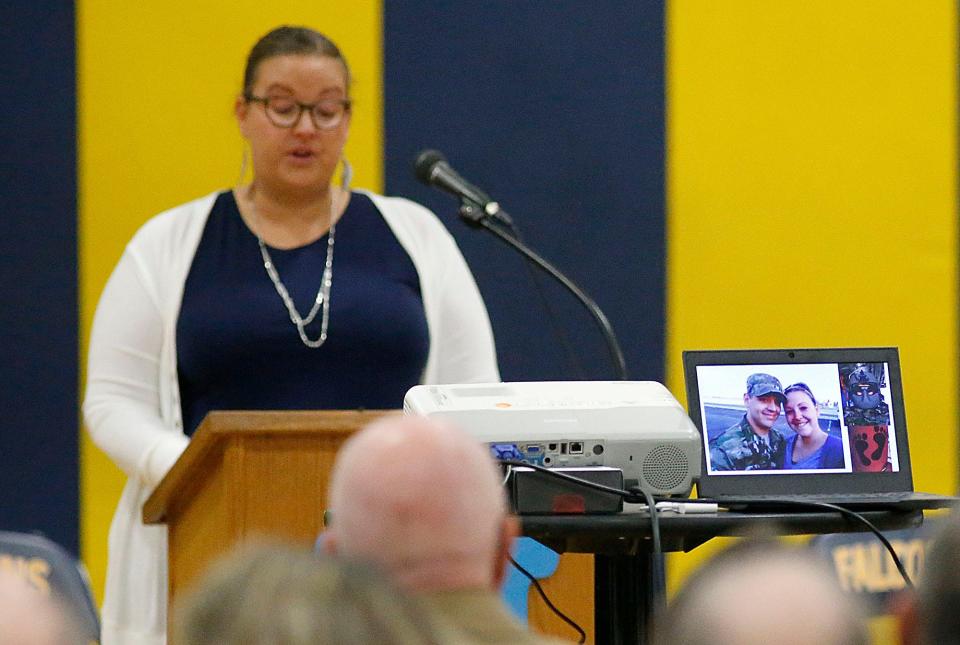 Brooke Martin, a Hillsdale Middle School educational aide, speaks as a photo of her and her active-duty husband is seen on a computer screen during a presentation at Hillsdale High School on Veterans Day, Friday, Nov. 11, 2022.