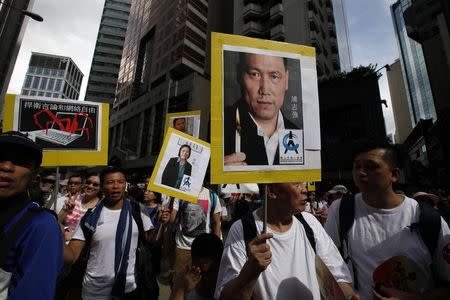 Protesters carry portraits of detained Chinese human rights lawyer Pu Zhiqiang (R) and mainland journalist Gao Yu as they join tens of thousands of others during a march to demand universal suffrage in Hong Kong July 1, 2014, the day marking the 17th anniversary of the territory's handover to China. REUTERS/Bobby Yip