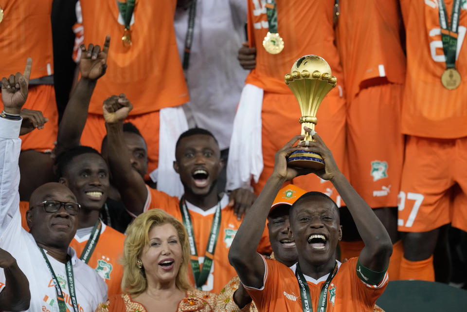 Max-Alain Gradel alza el trofeo de campeón luego de la victoria de Costa de Marfil por 2-1 ante Nigeria en la final de la Copa Africana de Naciones, el domingo 11 de febrero de 2024. (AP Foto/Themba Hadebe)